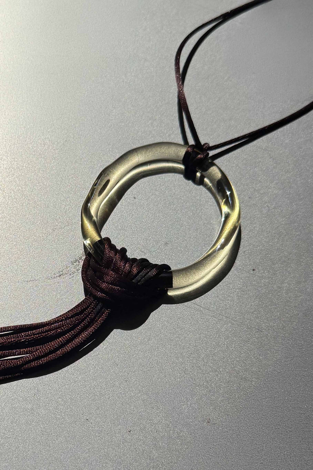 Close-up of handcrafted borosilicate glass ring champagne with brown satin cord fringe, Beryeni El Jaleo